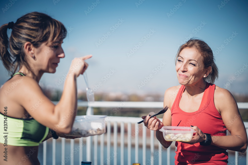 Wall mural Two women eat outdoors after training