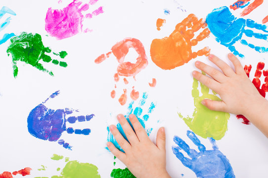 Kids hands making colored handprints on white background