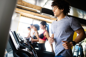 Fototapeta na wymiar Beautiful fit people exercising together in gym