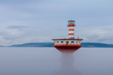 Farol no meio da neblina; seguran&ccedil;a de navega&ccedil;&atilde;o