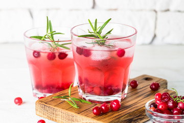 Cocktail with cranberry, vodka, rosemary and ice.