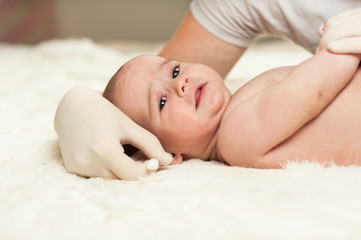 The child at the doctor's office and his ears are cleaned with a cotton swab.