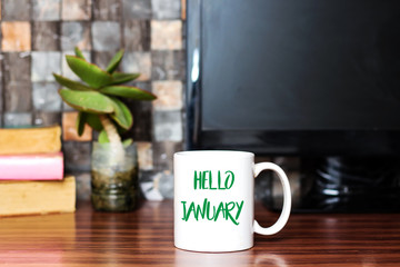 Hello January written on white coffee cup concept