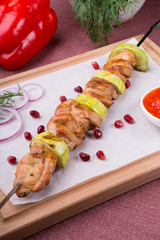 Grilled meat on metal skewer served with sauce