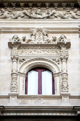 Window decorated with carving and sculptures in neo-baroque style