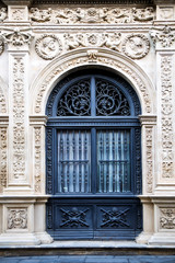 Entrance door of an ancient building with elegant wrought decorations