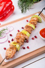 Grilled meat on metal skewer served with sauce
