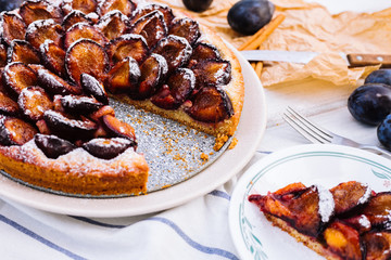 Homemade plum pie on the wooden background
