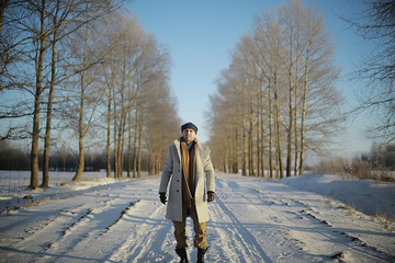 fashionable man in a coat / winter style, walk against the backdrop of the winter landscape, snowy weather, warm clothes