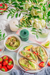 breakfast on the table, fresh snacks and berries, the table is decorated with flowers and candles
