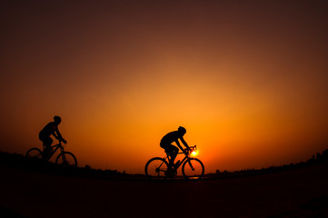 Fototapeta na wymiar Cyclist in sunset background.