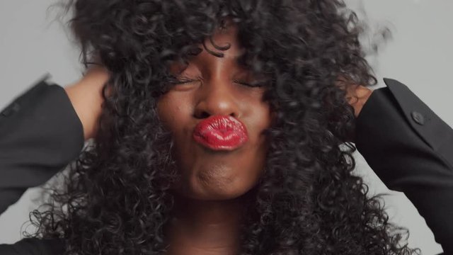 black mixed race businesswoman have fun with her curly hair sending kiss to camera. Looped video