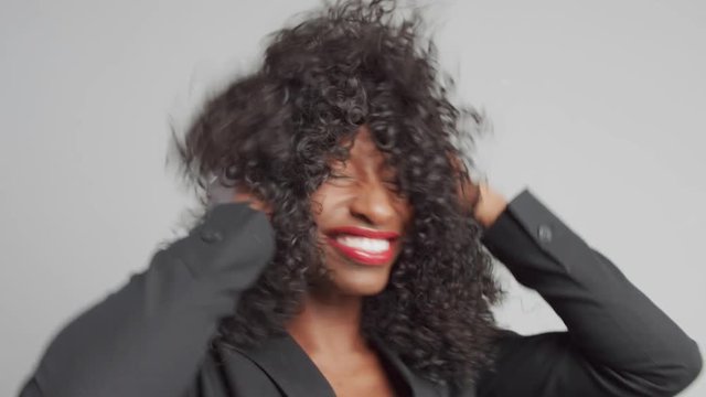 black mixed race businesswoman shake her curly hair touche it and smiling
