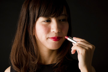 Obraz premium 口紅を塗る女性