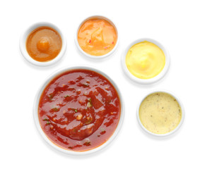 Different tasty sauces in bowls on white background