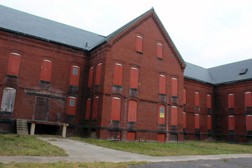 Fototapeta premium Boarded up and abandoned brick mental hospital asylum building 