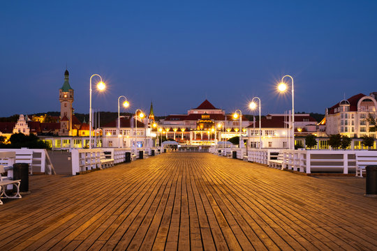 A long wooden pier in Sopot, Poland, with a view of the lighthouse
