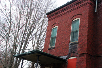 Boarded up and abandoned brick mental hospital asylum building 