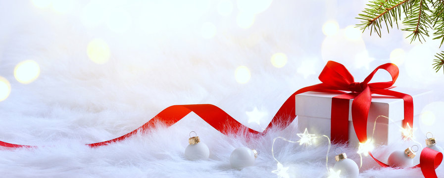 Christmas background with holidays gift box and Christmas decoration on red background