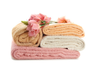 Fototapeta na wymiar Stack of clean soft towels with flowers on white background
