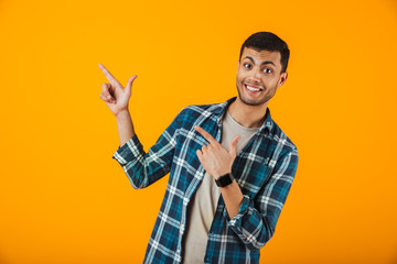 Cheerful young man wearing plaid shirt standing