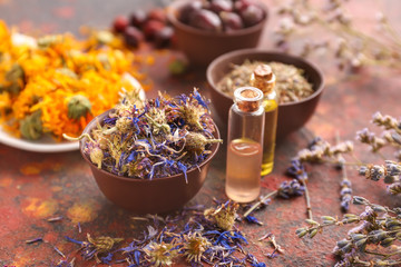 Aromatic dried flowers with essential oil on color table