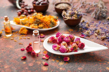 Aromatic dried flowers with essential oil on color table