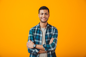 Cheerful young man wearing plaid shirt standing