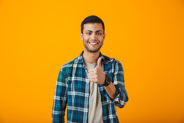 Cheerful young man wearing plaid shirt standing