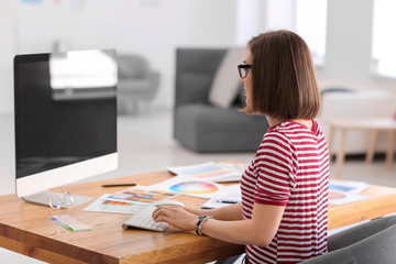 Beautiful young designer working in office