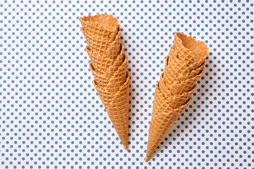 Waffle cones on color background