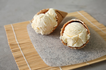 Fototapeta na wymiar Waffle cones with delicious ice cream on bamboo mat