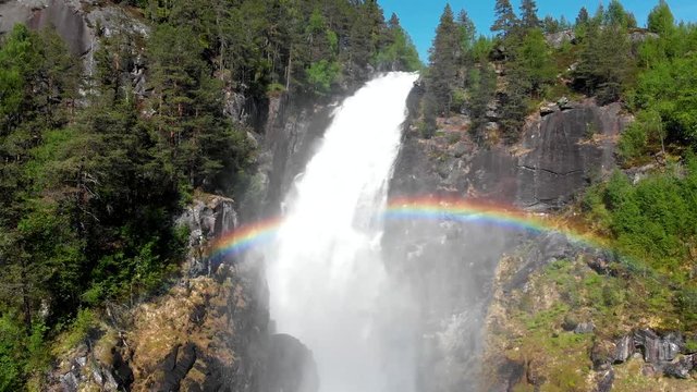 Latefossen waterfall, Norway. A beautiful rainbow is seen before a stream of falling water. Aerial shot, 4K