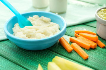 Bowl with healthy baby food on kitchen table