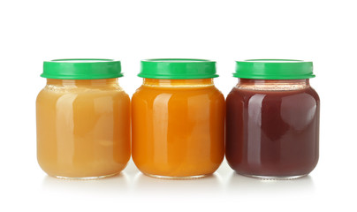 Glass jars with healthy baby food on white background