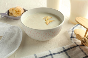 Bowl with healthy baby food on table