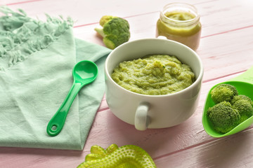 Bowl with healthy baby food on wooden table