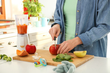 Woman preparing healthy baby food in kitchen