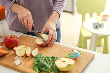 Woman preparing healthy baby food in kitchen