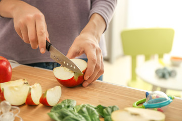 Obraz na płótnie Canvas Woman preparing healthy baby food in kitchen