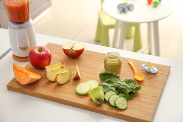 Wooden board with ingredients for baby food on kitchen table
