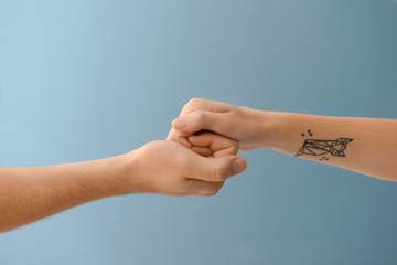 Man and woman holding hands on color background. Concept of support and help
