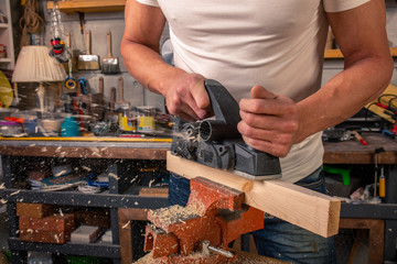 A carpenter works on woodworking the machine tool. Saws furniture details with a circular saw....