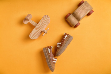 Baby shoes and toys on color background, flat lay