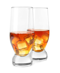 Glasses of whisky with ice on white background