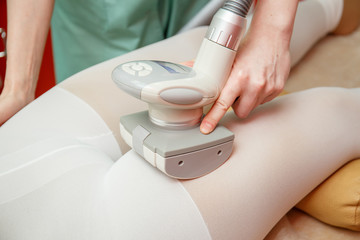 Woman having procedure of anti cellulite lpg massage, cosmetology clinic