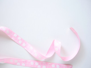 Pink curly ribbon on a  white