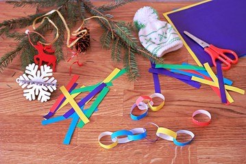 Obraz premium Making a garland from colored paper, step 2: sticking together colored paper strips into rings and joining them into a garland.