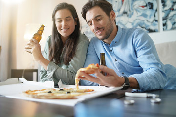  Happy relaxed couple sharing a pizza at home