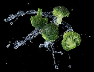 Broccoli with water splash or explosion flying in the air isolated on black background